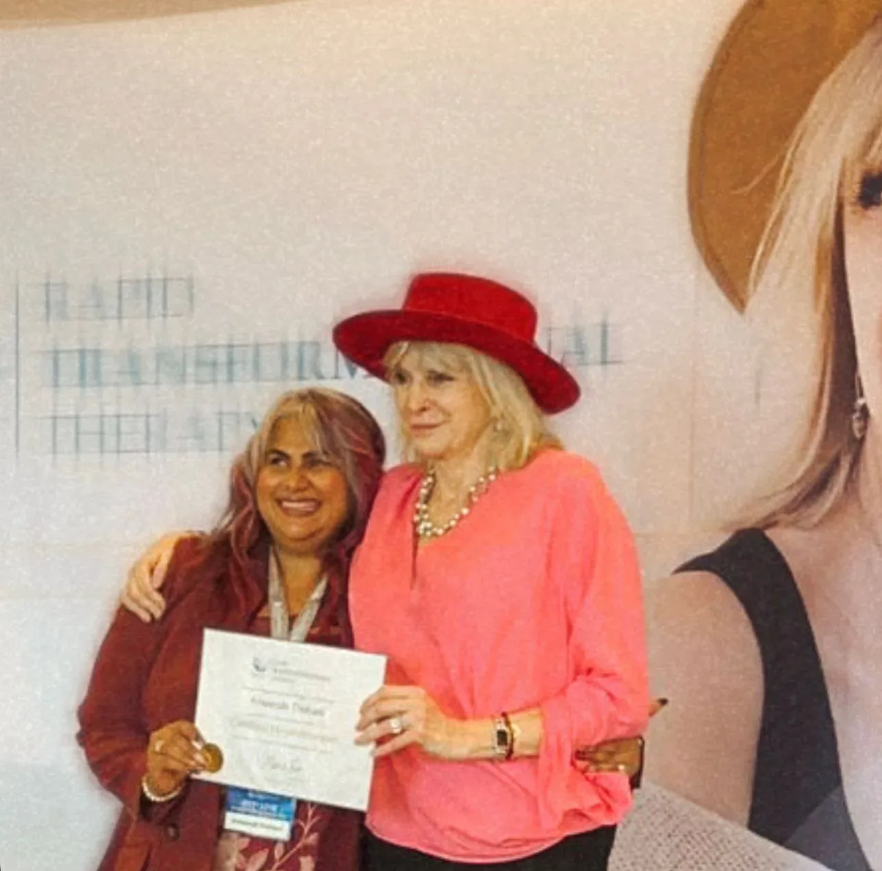 RTT Marisa Peer Giving certificate to Ameenah Thobani of Positive Enlightenment Canada who is the best RTT Therapist in Vancouver Canada.